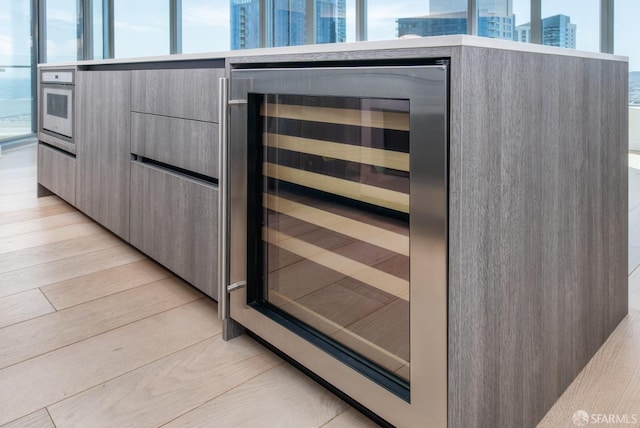 201 Folsom St Unit 38E, San Francisco, CA 94105 - kitchen view of beverage cooler, modern cabinets, light wood finished floors, gray cabinets, and a city view
