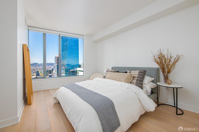 201 Folsom St Unit 38E, San Francisco, CA 94105 - bedroom with wood finished floors, a city view, and baseboards