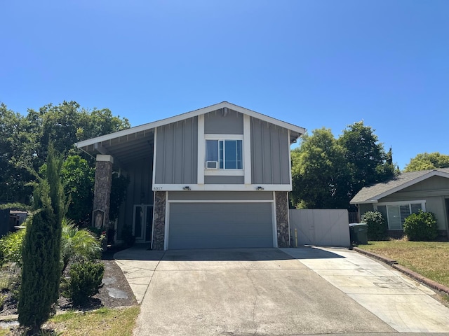 6517 Filaree Way, Sacramento, CA 95842 - view of front facade with board and batten siding, a garage, stone siding, driveway, and a gate