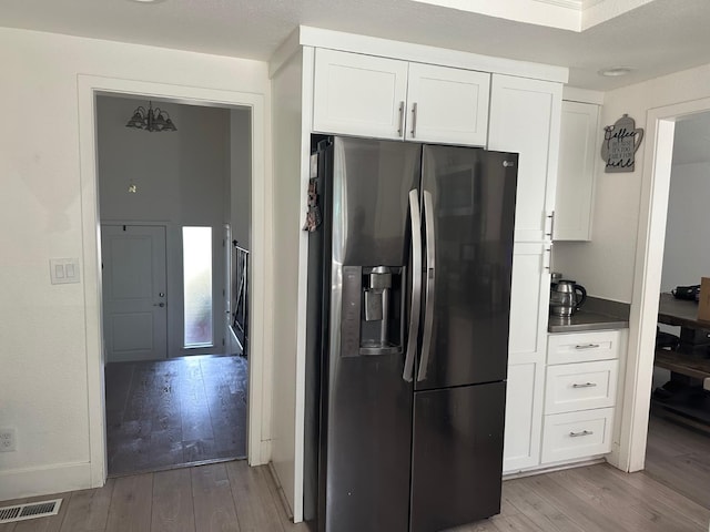 6517 Filaree Way, Sacramento, CA 95842 - kitchen with stainless steel fridge with ice dispenser, light wood-style flooring, white cabinets, and dark countertops