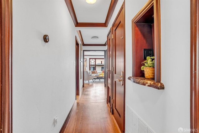 corridor featuring crown molding and light hardwood / wood-style floors