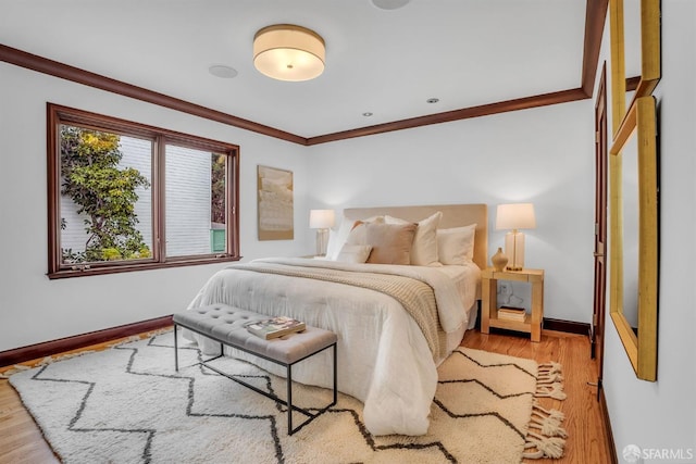 bedroom featuring crown molding and light hardwood / wood-style floors