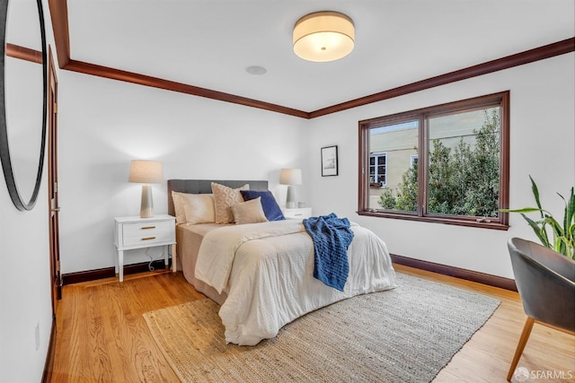 bedroom with ornamental molding and light wood-type flooring