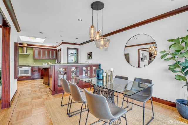 dining area featuring ornamental molding and a skylight