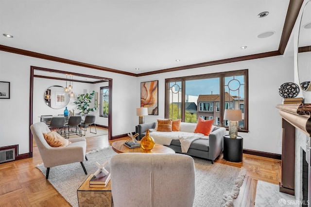 living room with light parquet flooring, a healthy amount of sunlight, a high end fireplace, and ornamental molding