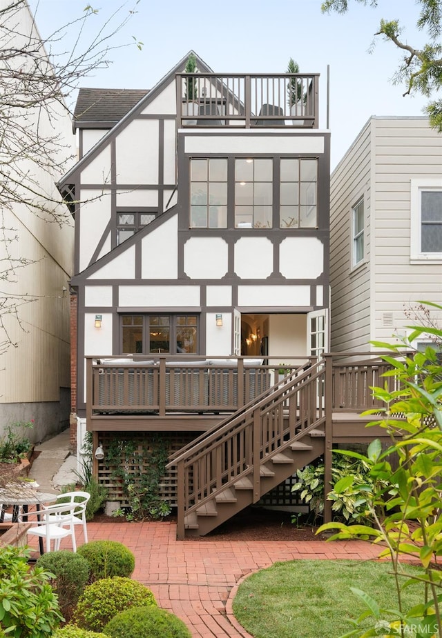 rear view of property featuring a patio and a balcony