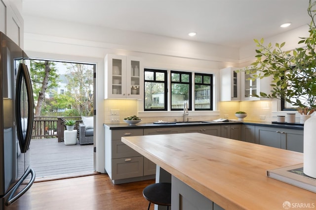 kitchen with gray cabinetry, sink, butcher block countertops, refrigerator, and light hardwood / wood-style floors