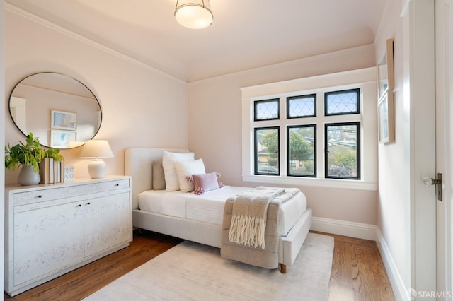 bedroom with wood-type flooring and crown molding