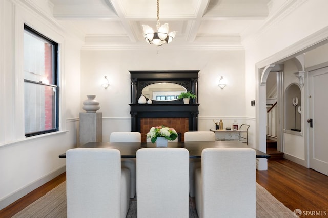 dining area featuring hardwood / wood-style flooring, a chandelier, beam ceiling, and coffered ceiling