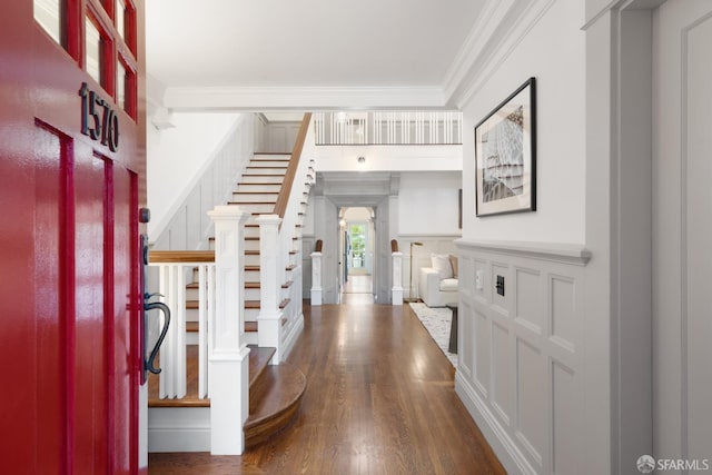 foyer entrance with dark hardwood / wood-style flooring and ornamental molding