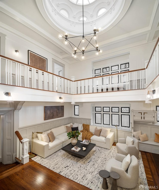 living room with a chandelier, a high ceiling, and hardwood / wood-style flooring