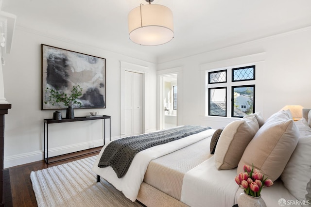 bedroom featuring dark hardwood / wood-style flooring and ensuite bath