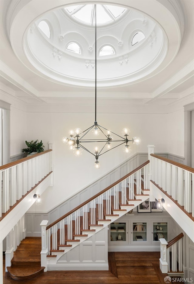 stairs with hardwood / wood-style flooring and a notable chandelier