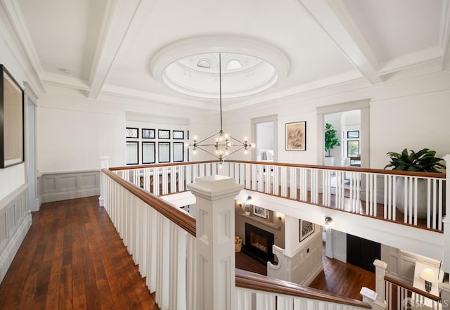 corridor with a notable chandelier, beam ceiling, dark hardwood / wood-style flooring, and coffered ceiling