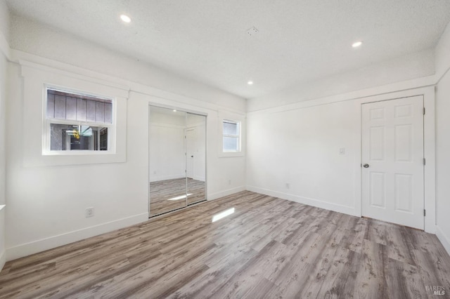 unfurnished room featuring a textured ceiling and light wood-type flooring