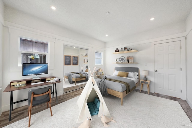 bedroom with hardwood / wood-style flooring and a textured ceiling