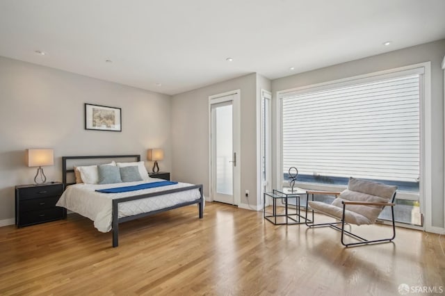 bedroom with access to exterior and light hardwood / wood-style floors