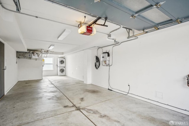 garage featuring a garage door opener and stacked washer / dryer