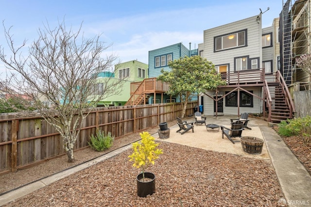 exterior space featuring a wooden deck, a patio, and a fire pit