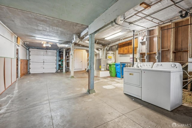 garage with a garage door opener, washing machine and dryer, and gas water heater