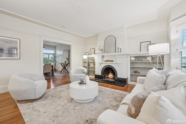 living room with hardwood / wood-style flooring and a brick fireplace