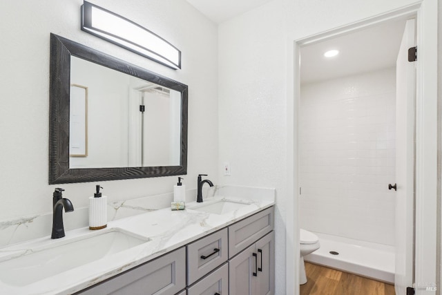 bathroom featuring walk in shower, vanity, toilet, and hardwood / wood-style floors