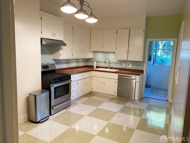 kitchen with white cabinetry, sink, stainless steel appliances, and pendant lighting