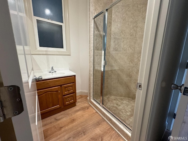 bathroom with vanity, a shower with shower door, and hardwood / wood-style floors