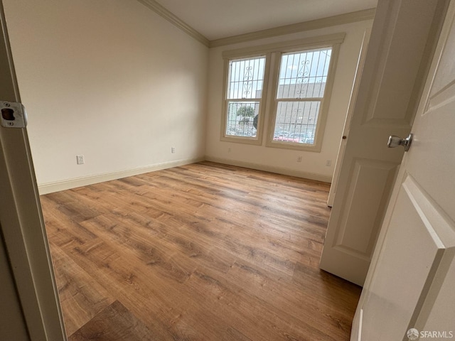 unfurnished room featuring light wood-type flooring and crown molding