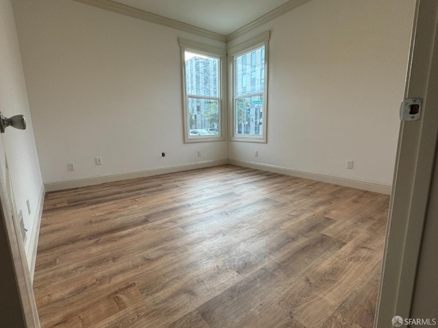 empty room with wood-type flooring and crown molding