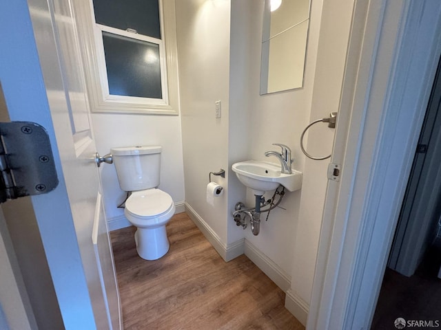 bathroom featuring wood-type flooring and toilet