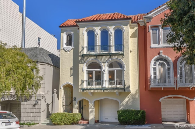 3544 Webster St, San Francisco, CA 94123 - view of front of property with a balcony, stucco siding, a tiled roof, and a garage