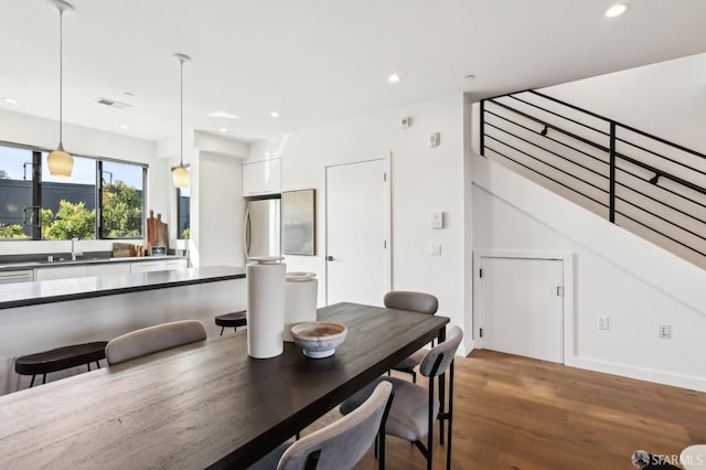 dining area with wood-type flooring and sink