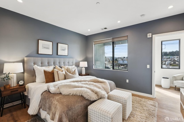 bedroom featuring hardwood / wood-style flooring and multiple windows