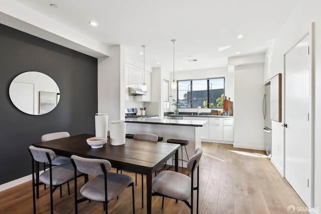 dining space with sink and light hardwood / wood-style flooring