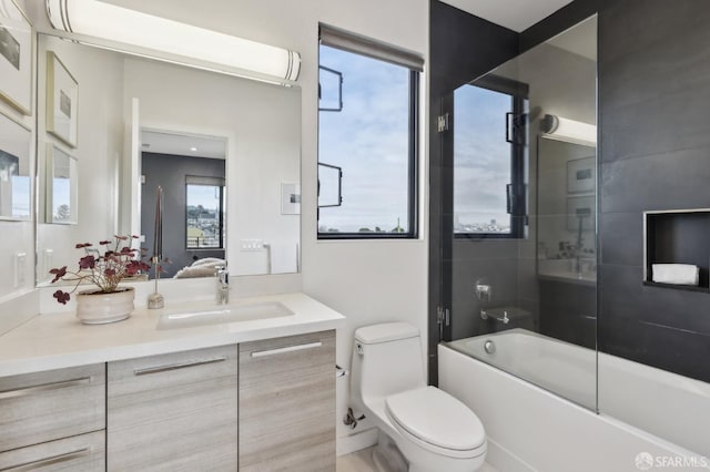 full bathroom featuring enclosed tub / shower combo, vanity, and toilet