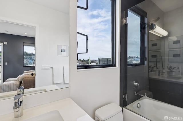 full bathroom featuring enclosed tub / shower combo, a healthy amount of sunlight, toilet, and vanity