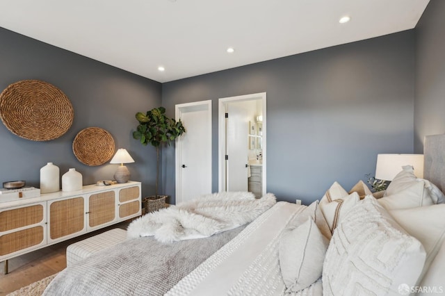 bedroom with hardwood / wood-style floors and ensuite bath