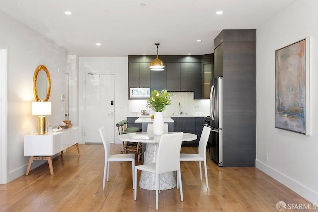 dining area with sink and light hardwood / wood-style flooring