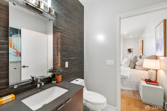 bathroom with vanity, tile walls, hardwood / wood-style floors, and toilet