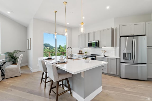 745 Redwood Rd, San Anselmo, CA 94960 - kitchen with appliances with stainless steel finishes, gray cabinets, tasteful backsplash, light wood finished floors, and an island with sink