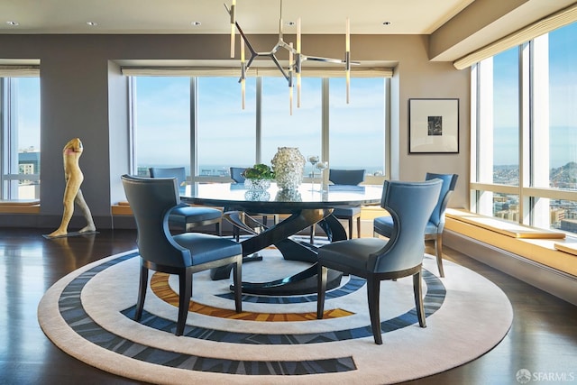 dining room with plenty of natural light, dark wood-type flooring, and an inviting chandelier