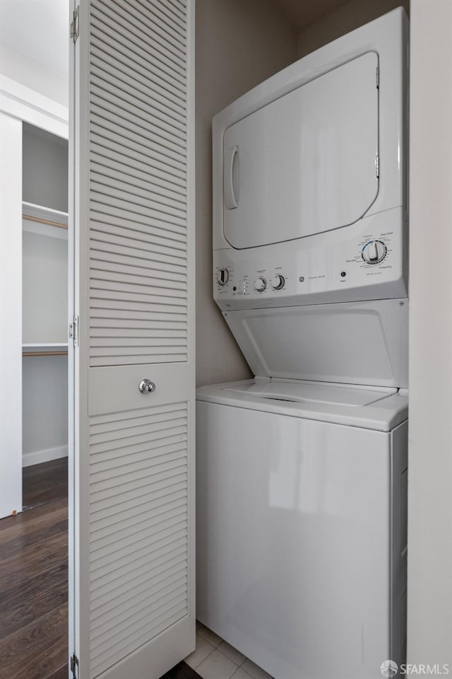 washroom with stacked washer / drying machine and laundry area