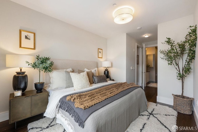 bedroom with wood finished floors and baseboards