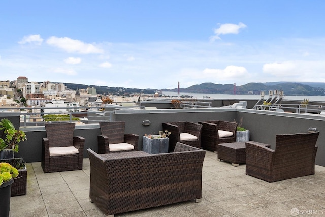 view of patio / terrace featuring a mountain view, an outdoor living space, a view of city, and a balcony