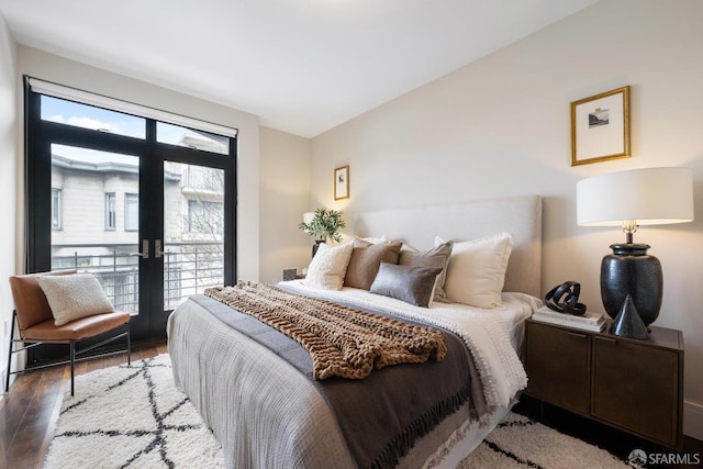 bedroom with access to exterior, wood finished floors, and french doors