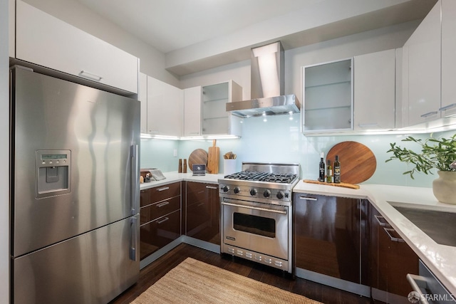 kitchen featuring wall chimney range hood, white cabinetry, appliances with stainless steel finishes, and light countertops