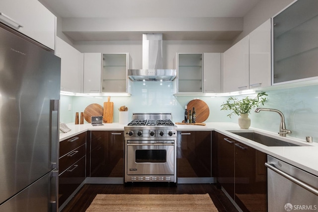 kitchen featuring a sink, light countertops, appliances with stainless steel finishes, wall chimney exhaust hood, and modern cabinets