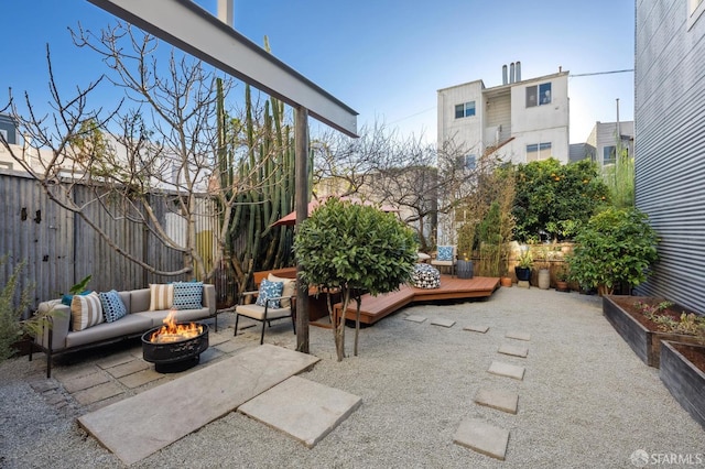 view of patio / terrace featuring a wooden deck and an outdoor living space with a fire pit