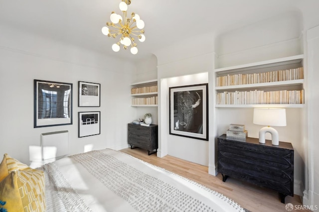 bedroom with wood-type flooring and an inviting chandelier